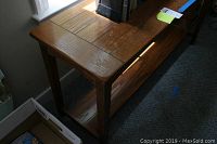 Wooden hall table showing top surface and part of the legs.