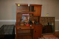 Front view of damaged wood computer desk with hutch and items placed on top and on floor next to it