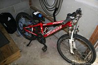 Full side view of red Specialized Hotrock trail mountain bike showing frame, tires, handlebars, and seat.