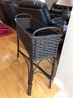 Side angled view showing the woven cane planter structure and stand legs