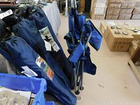 Four folded blue outdoor chairs with covers,