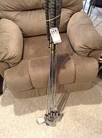 Golf irons set held together with rubber band showing grips and shafts, placed in chair.