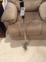 Photo showing three Silver Diamond irons leaning against a brown fabric armchair with visible shafts and grips.