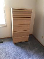 Front view of the six drawer chest, showing the light wood finish and horizontal groove handles.