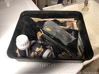 A plastic tray with assorted gun cleaning equipment including bottles and brushes.