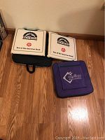 Two white Colorado Rockies seat cushions with 'Star of the American Road' and black carrying base, placed on wooden floor against wall