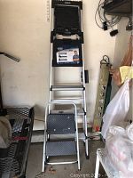 Photo showing the full 6 foot step ladder leaning against a wall with two-step stool placed in front.