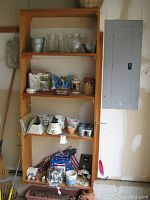 Wooden shelving unit with multiple shelves showing assorted outdoor decorations including vases, planters and decor items.