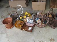 Lot contents showing various baskets, planters, kitchen decor items on a floor.