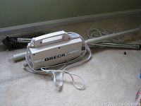 Oreck XL vacuum cleaner main unit with extensions and brush attachment on carpet.