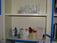 Shelf with nativity and angel figurines, decorative candles, and ceramic photo frames.
