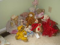 Photo showing nine stuffed animals arranged in a corner including teddy bears, a tiger, a small white lamb, and a red decorative item.