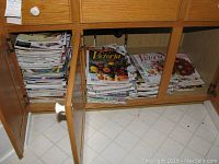 Photo showing many stacks of Victoria magazines and Southern Living magazines stored in a wooden cabinet