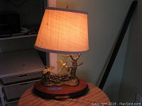 Front view of the Douglas McDonald brass sport lamp with beige shade, showing the brass pheasants and tree on wooden base.