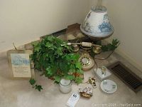 Five battery operated candles, faux ivy in basket, pink pressed glass lamp with chimney and shade, antique push button phone, porcelain trinket box visible