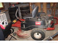 Full side profile of the red and black Toro riding mower showing deck and seat