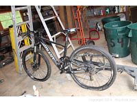 Full view of Giant Anthem X29 mountain bike mounted on Allen hitch rack in garage