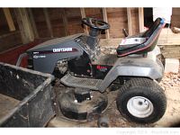 Side view of the entire riding mower showing body, deck, seat and tires