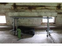 Front view of disassembled Thule ladder rack with crossbars and supports laid on barn floor