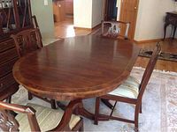 Full view of oval dining table with six chairs in room