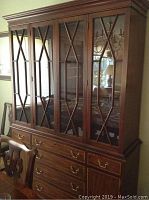 Front view of four-door mahogany china hutch with brass hardware