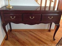 Front view of buffet/library table showing three drawers and brass pulls