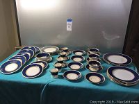 Full set laid out on table with plates, bowls and cups.