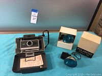 Polaroid Automatic 340 Land Camera open in original case, showing paperwork inside, two Polaroid Flashgun 268 flashes with blue diffusers, one boxed