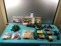 Full overview of the lot laid on table, showing all items including bridges, trees, power packs, and accessory bags.