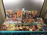 Overview of multiple comic books arranged in two rows on a table