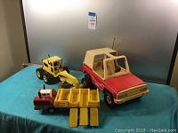 Full lot image showing all three vintage toy vehicles on green felt surface against a neutral background