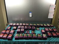 Wide shot showing approximately 425 sealed packs of Elvis Presley collector cards arranged on a blue tablecloth with different pack images visible