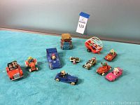 The full group of 10 vintage toy vehicles, showing color, size, and characters.