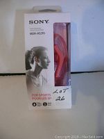 Front of original boxed Sony MDR-AS210 red sports headphones showing the product through a clear window and branding