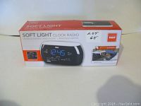 Boxed RCA Soft Light Clock Radio with motion activation and soft light control, showing front of the box with product image and details.