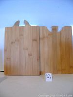 Two bamboo cutting boards standing upright showing interlocking design with handle cutouts.