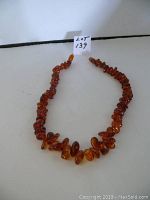 Full view of the amber necklace extended showing bead size variation and color