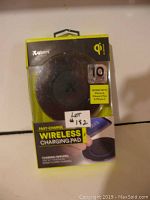 Front view of Atomi wireless charging pad in original packaging, showing compatibility with Apple iPhone X/8/8 Plus, Samsung Galaxy Note 8/S8/S8+ and all Qi-enabled devices. Black color.