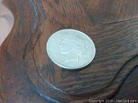 Obverse side of 1922 silver dollar coin showing Liberty's head profile on wooden surface.