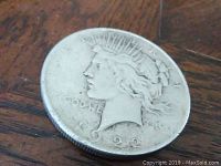 Front close-up photo of 1922 Liberty Peace Silver Dollar on a wooden surface showing worn details and date
