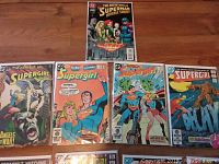 Lot of 4 comics with visible covers including Supergirl and Superman titles, bagged and boarded.