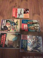 Flat lay image of all five vintage comic books on wooden floor, showing cover artwork and titles.