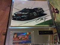 Framed signed photo and racing card of Dale Earnhardt Jr featuring his number 8 black Budweiser NASCAR car.
