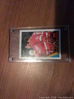 Adam Oates rookie card in protective plastic case, showing front face with player in Red Wings uniform, O-Pee-Chee branding, and rookie card status.