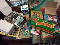 Image showing many packs and unopened boxes of Topps baseball cards along with other assorted sports cards.