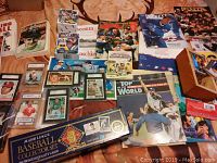 Overview of multiple baseball and hockey books, graded Beckett hockey cards, and a boxed MLB 1992 collector set on a wooden surface.