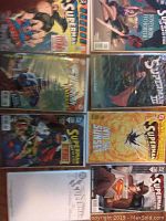 Eight Superman comics displayed face-up, showing front covers in bags and boards for protection.