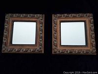 Front view of the two matching decorative mirrors shown side by side against black background.