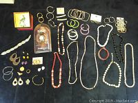 Full overview of all costume jewelry items arranged on dark fabric