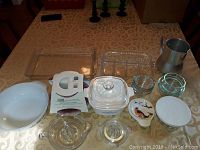 Wide view of assorted kitchen items including Pyrex dish, glassware, pitcher and bowls.